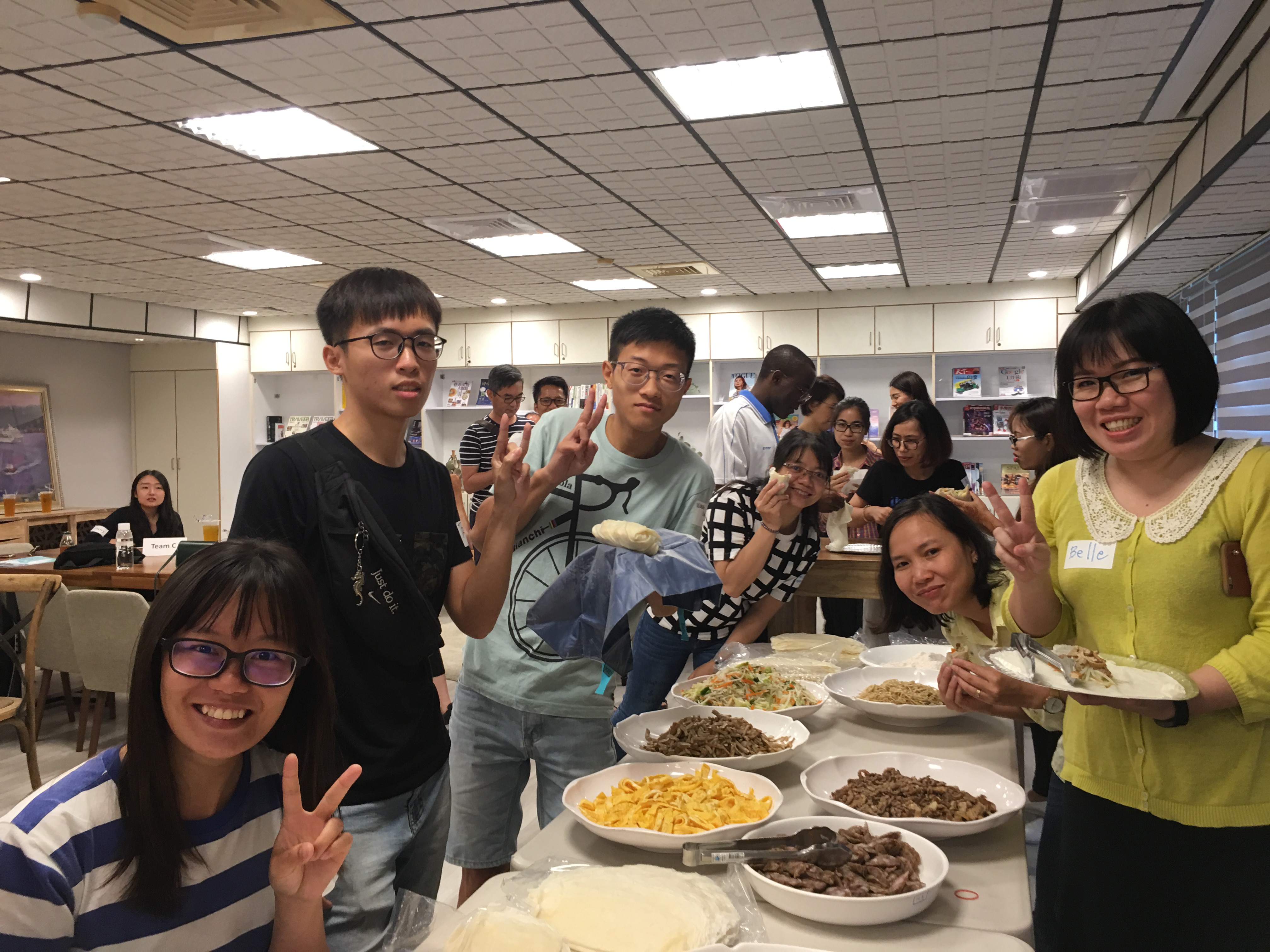 同仁與外籍學生一同品嚐春捲，分享臺灣文化。
